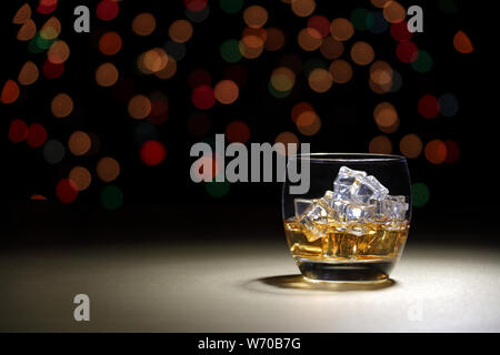 A scotch in tumbler on gold surface with bokeh background Stock Photo