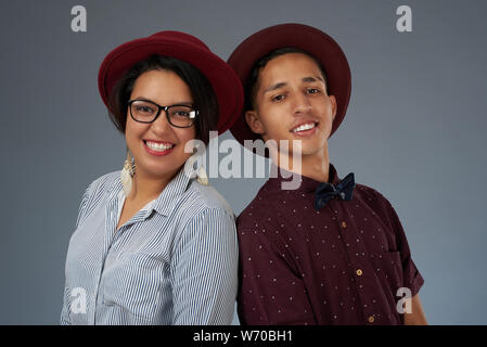 Portrait of hispanic young couple in red hats isolated on gray studio background Stock Photo