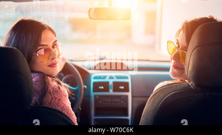 Two young women friends in car looking back Stock Photo