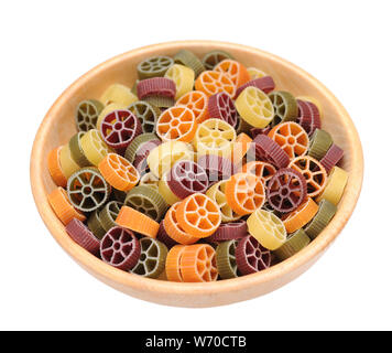 colorful rotelle pasta in wooden bowl isolated on white background Stock Photo