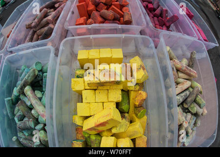Colorful pieces of chalk sit in plastic containers at chalk art contest. Stock Photo