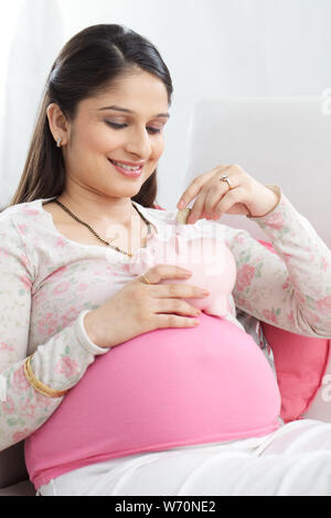 Pregnant woman saving money for her baby Stock Photo