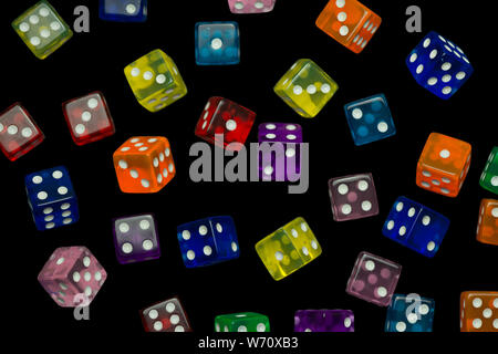 many falling translucent  multicolored  dices with white dots on black background Stock Photo