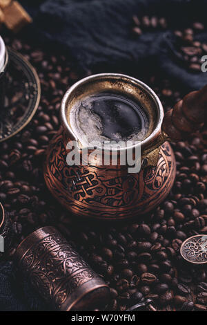 Close up of hot coffee in Turkish cooper and coffee beans Stock Photo