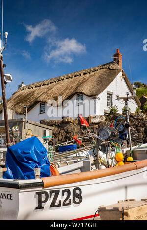 UK, England, Cornwall, Sennen Cove, fishing boats on slipway before thatched seafront holiday cottage Stock Photo