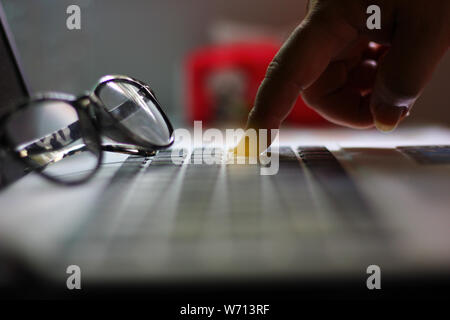 the worker pointing finger on button of laptop.worker is push button delete his job or push button enter to save his work. Stock Photo