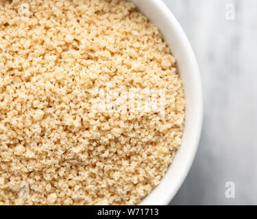Finely ground egusi melon seeds in a white bowl, off centre to the left Stock Photo