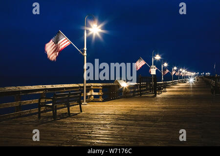American flags wave in the breeze on the Ventura Pier, decorated for Memorial Day. Stock Photo