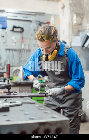 Woman mechanic working in metal workshop Stock Photo