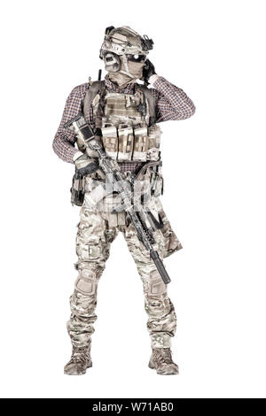 Strikeball enthusiast in checkered shirt wearing military ammunition, face mask, helmet and radio headset, tactical glasses, camo pants, armed service rifle and handgun studio shoot isolated on white Stock Photo
