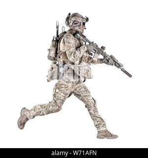 Army soldier, equipped infantryman, airsoft player in camouflage battle uniform, helmet and tactical radio headset jumping, running with assault rifle in hand studio shoot isolated on white background Stock Photo
