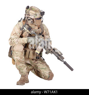 Army special forces infantry in battle uniform, radio headset on helmet, armed service rifle, standing on knee, waiting in ambush, patrolling area, observing territory studio shoot isolated on white Stock Photo