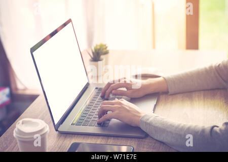 Business woman using laptop computer do online activity on wood table at home office. Stock Photo