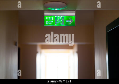 The EXIT indicator in case of fire is fixed on the ceiling of the corridor. Stock Photo