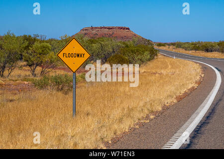 Flood way street sign besides road in Australian bush landscape Stock Photo