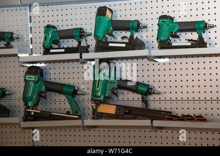 set of green power drills on metal shelves Stock Photo
