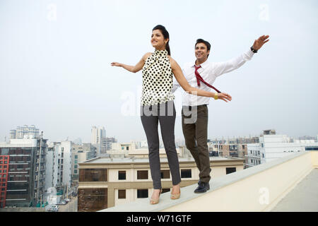 Two business executives walking on ledge Stock Photo