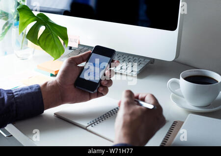 Businessman using (touch screen) smartphone for work with worktable Stock Photo
