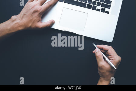 Young man working on laptop.Male hand using,typing modern computer.Business concepts.Flat lay design,top view Stock Photo