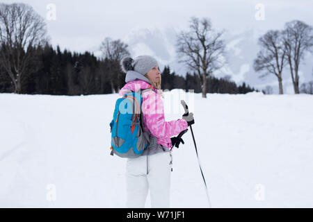 woman with hiking poles in winter nature Stock Photo