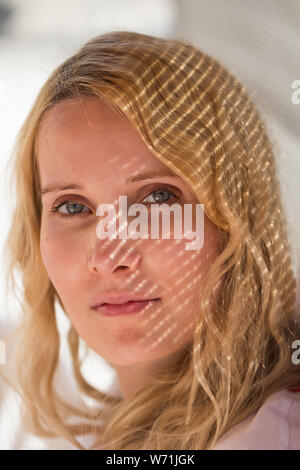 closeup of woman face with light and shadow pattern Stock Photo