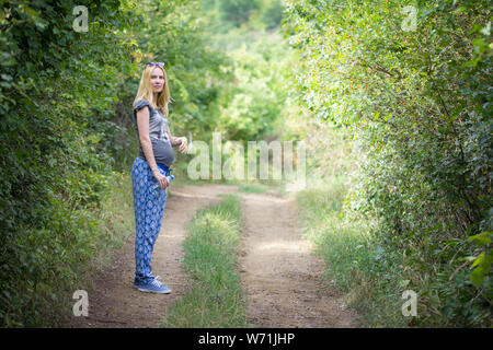 young pregnant woman posing in nature Stock Photo