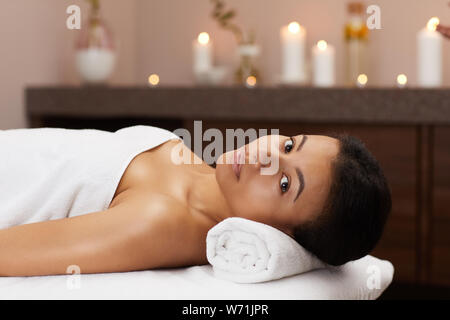 Portrait of beautiful mixed-race woman looking at camera while relaxing in luxury SPA, copy space Stock Photo