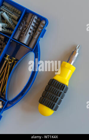 Tool box with screws, various types of parts and screwdrivers On a gray background. Do it yourself. Repair concept. Flat lay. vertical photo. Stock Photo
