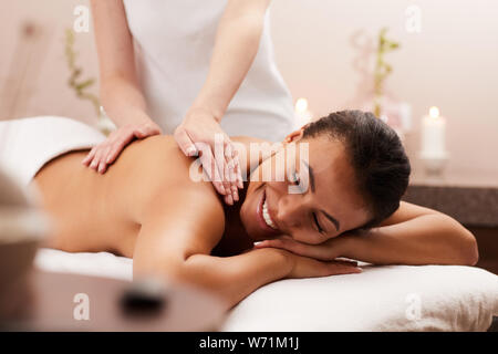 Portrait of beautiful woman smiling happily while enjoying massage in luxury spa, copy space Stock Photo