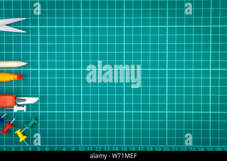 Knives cutter, pencil, scissor and stationary on white green cutting mat background. Selective focus and copy space Stock Photo