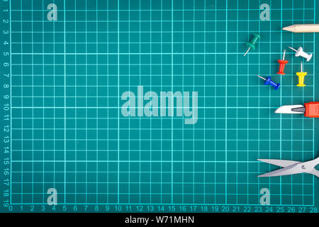 Knives cutter, pencil, scissor and stationary on white green cutting mat background. Selective focus and copy space Stock Photo