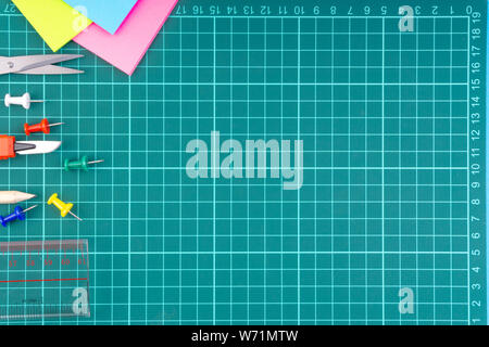 Knives cutter, pencil, scissor and stationary on white green cutting mat background. Selective focus and copy space Stock Photo