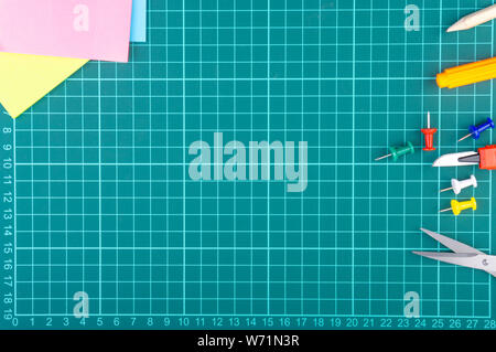 Knives cutter, pencil, scissor and stationary on white green cutting mat background. Selective focus and copy space Stock Photo