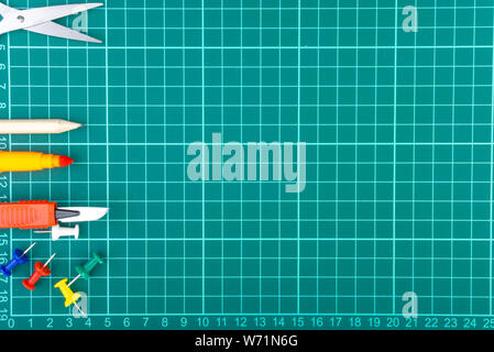 Knives cutter, pencil, scissor and stationary on white green cutting mat background. Selective focus and copy space Stock Photo