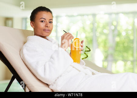 Portrait of beautiful woman relaxing by pool in SPA and drinking cocktail, copy space Stock Photo