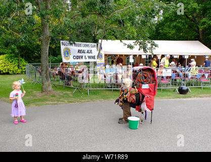 Hotham Park, Bognor Regis, West sussex, England, UK. Busker dressed as an old man performing to a little girl at fair in park Stock Photo