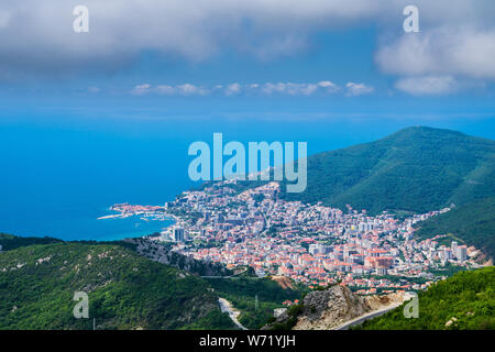 Montenegro, Wide view above old town of budva and modern city buildings in bay area of azure water becoming a big city in valley Stock Photo