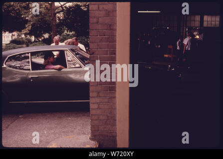 CAR ENTERING A SAFETY INSPECTION BUILDING IN AN EASILY ACCESSIBLE LOCATION IN DOWNTOWN CINCINNATI, OHIO. SAFETY INSPECTIONS BEGAN IN 1940 AND WERE DONE ON A SEMI-ANNUAL BASIS UNTIL IT BECAME AN ANNUAL EVENT IN JANUARY, 1975. IN ADDITION TO THE SAFETY CHECK ALL LIGHT DUTY, SPARK IGNITION POWERED MOTOR VEHICLES ARE HOOKED UP TO AN EXHAUST ANALYZER AND MONITORED FOR CARBON MONOXIDE AND HYDROCARBON EMISSIONS. UNDER THE OLD SYSTEM 800 TO 1,200 VEHICLES A DAY WERE CHECKED Stock Photo