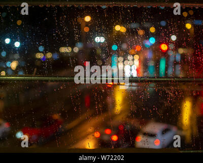 Night lights urban scene. When rainy weather from behind the window Stock Photo