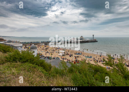 Bournemouth, UK. 4th August 2019. Overcast weather with stormy skies doesn't deter the crowds of enjoying Bourneomuth beach and people swimming in the sea. Credit: Thomas Faull/Alamy Live News Stock Photo