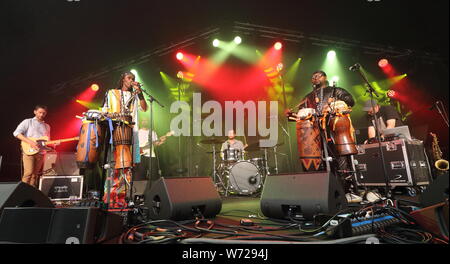 Fofoulah band, a London-based group mixing Senegalese voice and West African rhythms with dub bass lines, sci-fi synths, raw guitars and intense grooves perform on Day Two of the world renowned Cambridge Folk Festival at the Cherry Hinton Hall in Cambridge. Stock Photo
