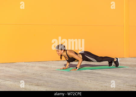 Little girl practicing yoga, doing push ups, press ups, four