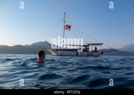 Late afternoon sun and a Turkish Gulet sales in the calm Mediterranean sea near Kalkan Stock Photo