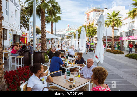 Torremolinos, Malaga province, Andalusia, Spain - June 19th, 2019 : People sit at an outdoors cafe at the Costa del Sol square at the center of Torrem Stock Photo