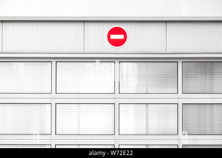 No entry traffic sign on gray industrial wall, minimalist architecture with warning road sign, red color pop up Stock Photo