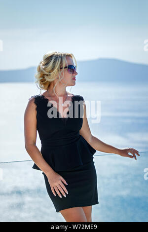 Beautiful woman in dress against the sea  of Santorini island, Greece