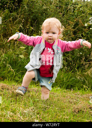 Toddler playing in a field, UK Stock Photo