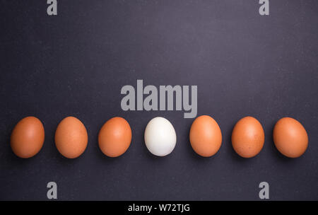 Fresh egg and boiled egg without shell. Top view on black stone background Stock Photo