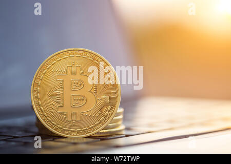 Macro bitcoin. Golden coin with bitcoin symbol on laptop computer Stock Photo