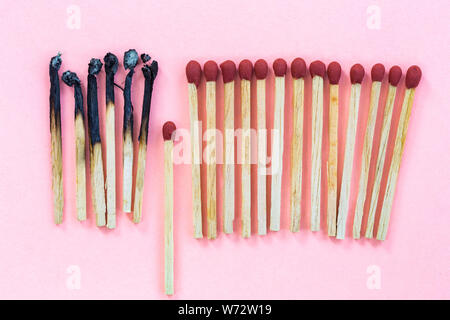 Naw and burning wood match stick with one of stick in different level to stop burning to the other. Top view Stock Photo